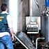 Guardia Civil officer inspecting industrial equipment in a facility. - Olive Oil Times
