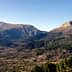 Panoramic view of Tietar Valley featuring mountains and greenery under a clear sky. - Olive Oil Times