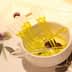 A small white bowl containing yellow oil and several clear pipettes arranged inside it. - Olive Oil Times