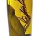 Bottle of infused olive oil containing herbs and leaves submerged in oil. - Olive Oil Times
