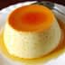 A smooth custard dessert topped with a layer of caramel sauce on a white plate. - Olive Oil Times