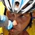 Cyclist in a yellow jersey drinking from a water bottle during a race. - Olive Oil Times