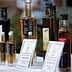 Assorted bottles of olive oil with labels displayed on a table at an event. - Olive Oil Times