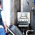 Civil Guard officer in a blue vest examining industrial equipment in a facility. - Olive Oil Times