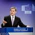 A man speaking at a podium during a European Commission press conference with the EU emblem in the background. - Olive Oil Times