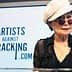 Yoko Ono wearing a white hat and sunglasses speaking at a podium with a sign for Artists Against Fracking. - Olive Oil Times