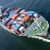 Aerial view of a cargo ship loaded with colorful shipping containers on water. - Olive Oil Times