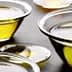 Several glass bowls containing olive oil, varying in size and filled with a golden liquid. - Olive Oil Times