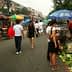 People shopping at a street market with various vegetables displayed on the ground. - Olive Oil Times