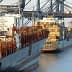 Two cargo ships docked at a port with containers stacked on their decks. - Olive Oil Times