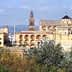 Historic buildings in Cordoba, featuring intricate architecture and a prominent bell tower. - Olive Oil Times