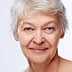 Close-up portrait of an older woman with short gray hair and a neutral expression. - Olive Oil Times