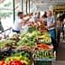 A market stall displaying a variety of fresh vegetables including peppers, cucumbers, and carrots. - Olive Oil Times