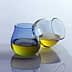 Two glass containers with olive oil, one blue and one clear, positioned on a reflective surface. - Olive Oil Times