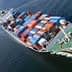Cargo ship with multiple stacked shipping containers navigating through water. - Olive Oil Times
