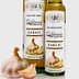 Two bottles of garlic olive oil with a garlic bulb in front on a neutral background. - Olive Oil Times