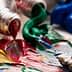 Opened paint tubes with red, green, blue, and yellow paint squeezed out onto a surface. - Olive Oil Times