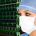 Healthcare professional in a surgical mask observing heart rate monitor with ECG readings in the background. - Olive Oil Times