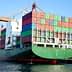 Large container ship loaded with colorful shipping containers at a dock. - Olive Oil Times