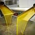 Golden olive oil flowing from two spouts into a collection container during processing. - Olive Oil Times