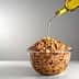 A glass bowl filled with cereal being drizzled with olive oil from a bottle. - Olive Oil Times