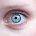 Close-up image of a human eye featuring a blue iris and dark pupil. - Olive Oil Times