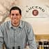 Man in a checkered shirt standing behind a counter at Lucero Olive Oil Company. - Olive Oil Times