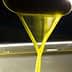Stream of golden olive oil pouring from a spout into a container. - Olive Oil Times