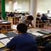 Students engaged in reading and studying at tables in a library setting. - Olive Oil Times