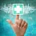 A hand pointing at a digital health icon featuring a medical cross on a blue background. - Olive Oil Times