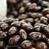 Close-up view of shiny black olives displayed in a natural setting. - Olive Oil Times