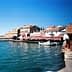View of a coastal area in Ayvalik featuring boats and buildings along the waterfront. - Olive Oil Times