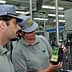 Two individuals examining a bottle of olive oil in a production facility. - Olive Oil Times