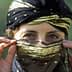 Woman with a decorative black and gold headscarf partially covering her face, revealing her eyes. - Olive Oil Times