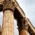 Close-up view of ancient Greek columns featuring Corinthian capitals and weathered stone. - Olive Oil Times