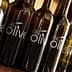 Several dark glass bottles with a label that reads 'We Olive' displayed in a row. - Olive Oil Times