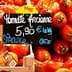 Display of ripe tomatoes with a price tag indicating 5.90 € per kilogram in a market setting. - Olive Oil Times