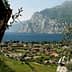 A scenic view of Lake Garda featuring mountains and a village with terracotta-roofed buildings. - Olive Oil Times