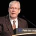 A man with glasses speaking at a podium with a sign that reads 'Palais des congrès de Montréal'. - Olive Oil Times