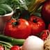 A variety of fresh vegetables and fruits including tomatoes, apples, and greens arranged together. - Olive Oil Times