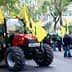 A red tractor parked on a street with yellow flags during a protest gathering. - Olive Oil Times