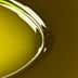 Close-up of olive oil in a spoon with a smooth, glossy surface reflecting light. - Olive Oil Times