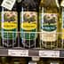 A selection of olive oil bottles displayed on a store shelf, featuring different brands and types. - Olive Oil Times