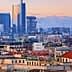 Panoramic view of Milan featuring modern skyscrapers and traditional buildings under a sunset sky. - Olive Oil Times