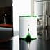Compact white and green kitchen appliance with a button on top, placed on a dark countertop. - Olive Oil Times