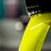 Stream of bright yellow olive oil pouring from a metal container into a bowl. - Olive Oil Times