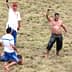Competitors in a Turkish oil wrestling match with one wrestler celebrating a victory in a grassy field. - Olive Oil Times