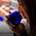 Individual smelling olive oil from a blue tasting cup during a tasting session. - Olive Oil Times