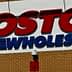 Sign displaying the Costco Wholesale logo on a brick wall. - Olive Oil Times