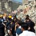 Emergency responders and volunteers assisting at a collapsed building site after an earthquake. - Olive Oil Times